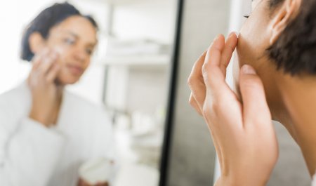 Woman applying cream on her face