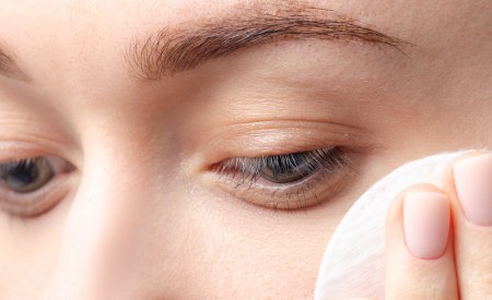 Le nettoyage de la peau Une femme se passe un coton sur le visage