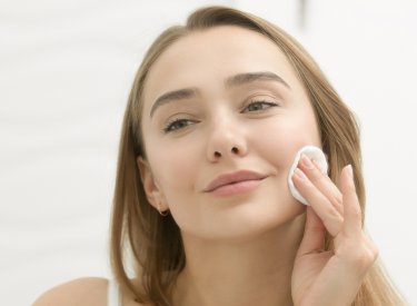 Les bons gestes nettoyage Une femme en train de de nettoyer le visage
