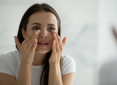 femme qui hydrate son contour de l’œil