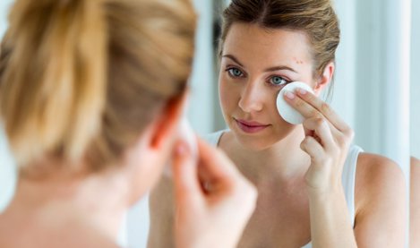 Woman with acne-prone skin cleaning her face